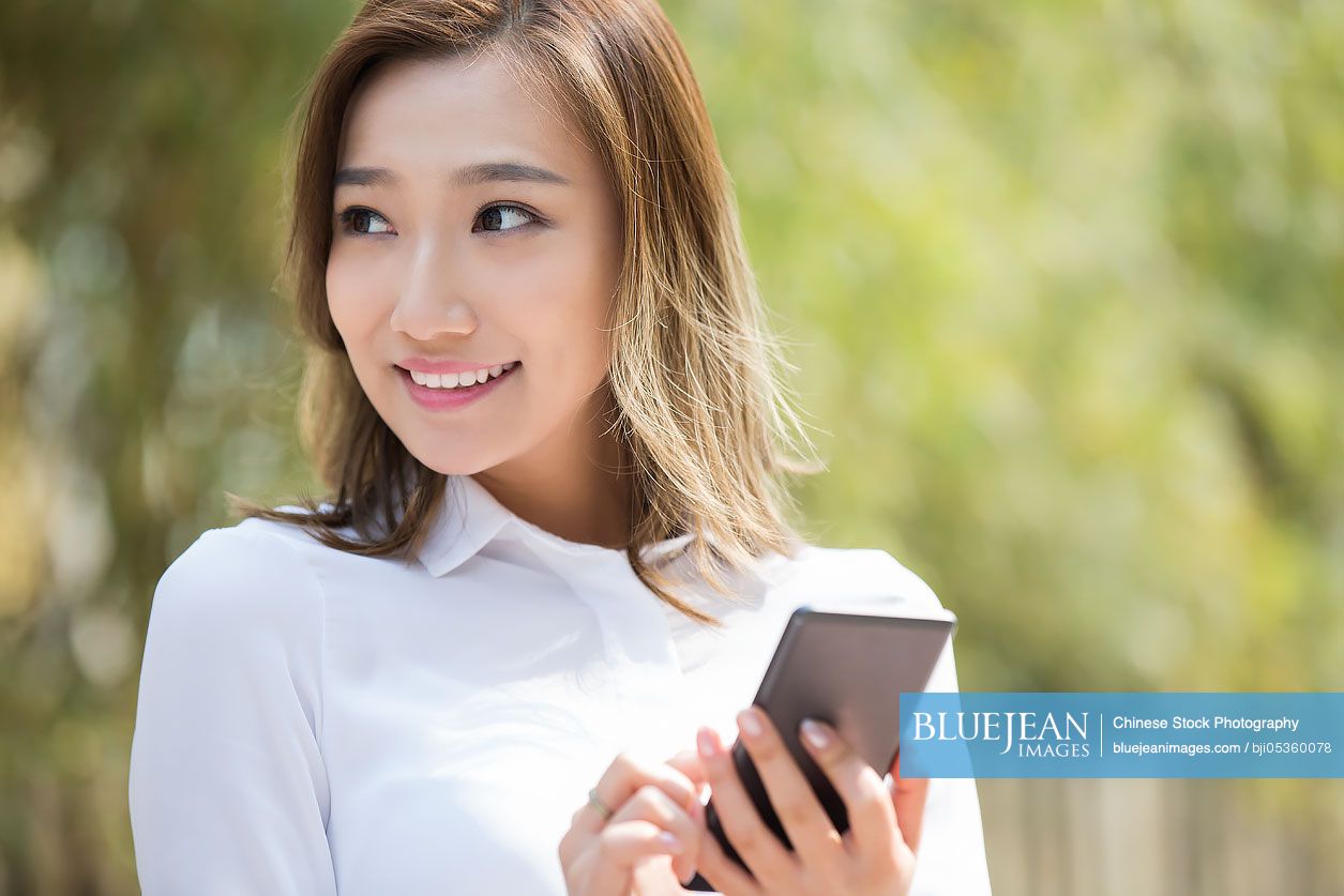 Young Chinese businesswoman holding a smart phone