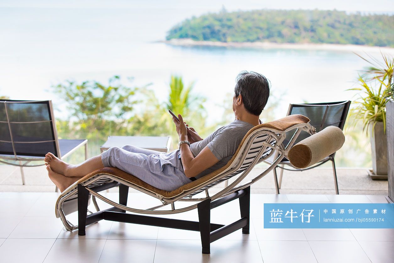 快乐的老年男子在阳台上看风景