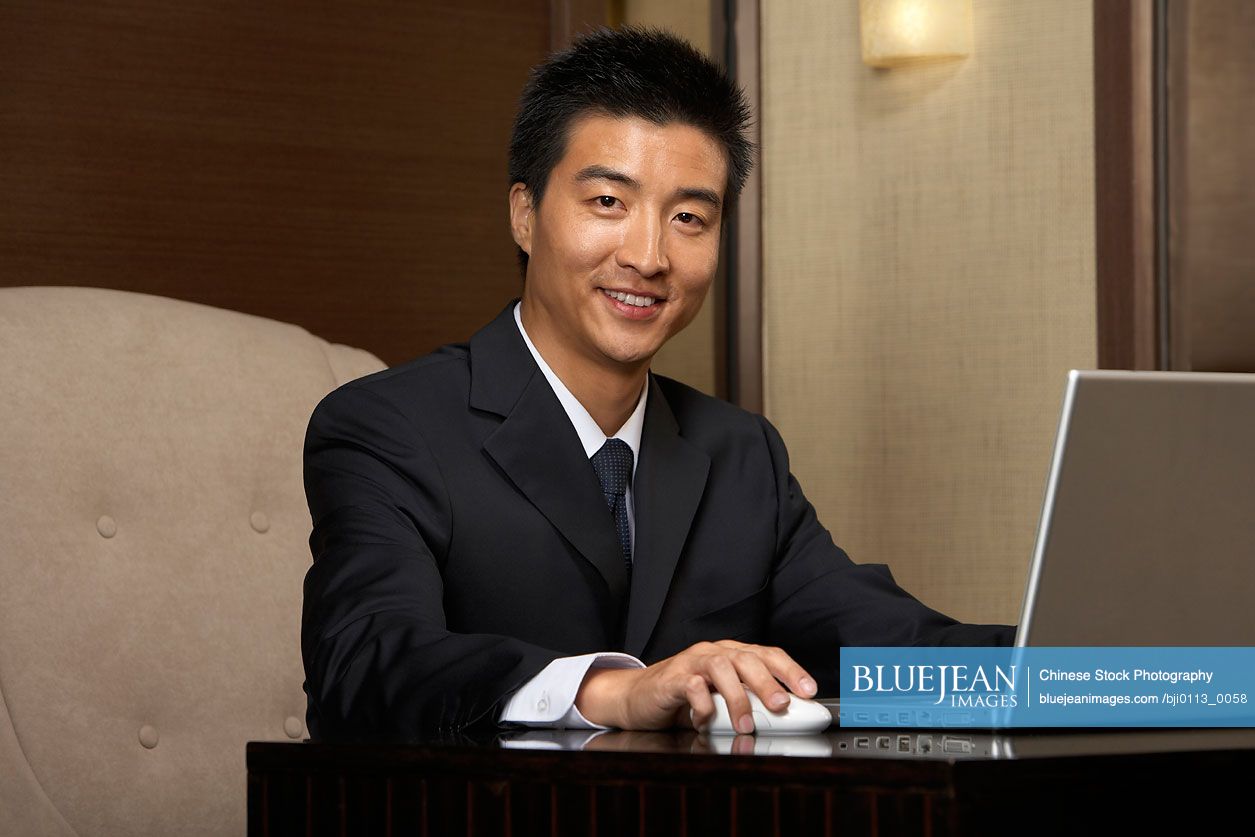 Chinese businessman using laptop