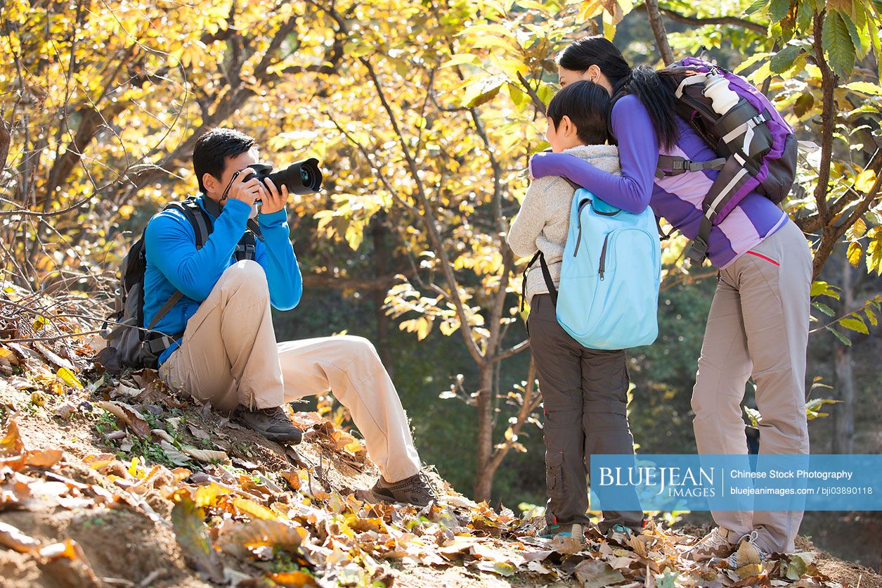 Young Chinese family taking pictures on a hike