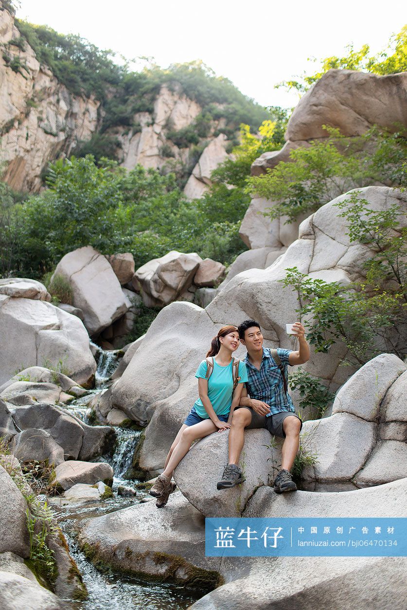 快乐的年轻情侣在户外使用手机