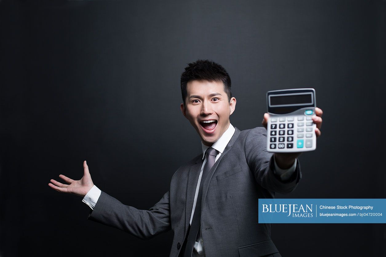 Excited Chinese businessman showing a calculator