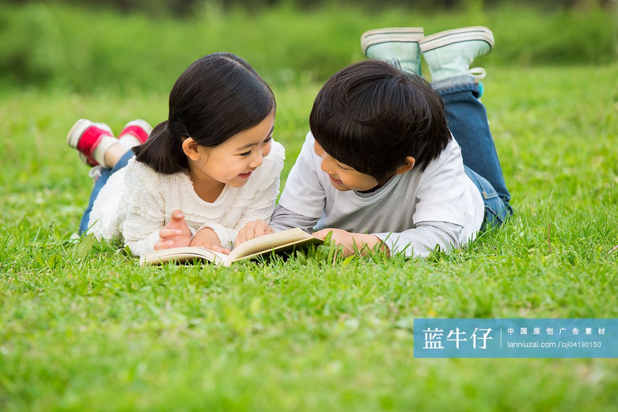 小男孩和小女孩在草地上读书
