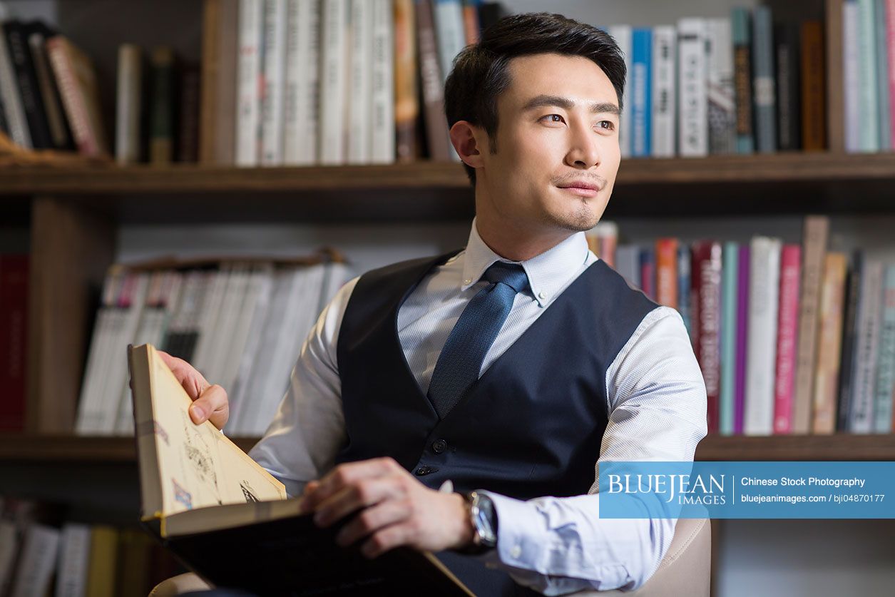 Young Chinese businessman thinking in his study