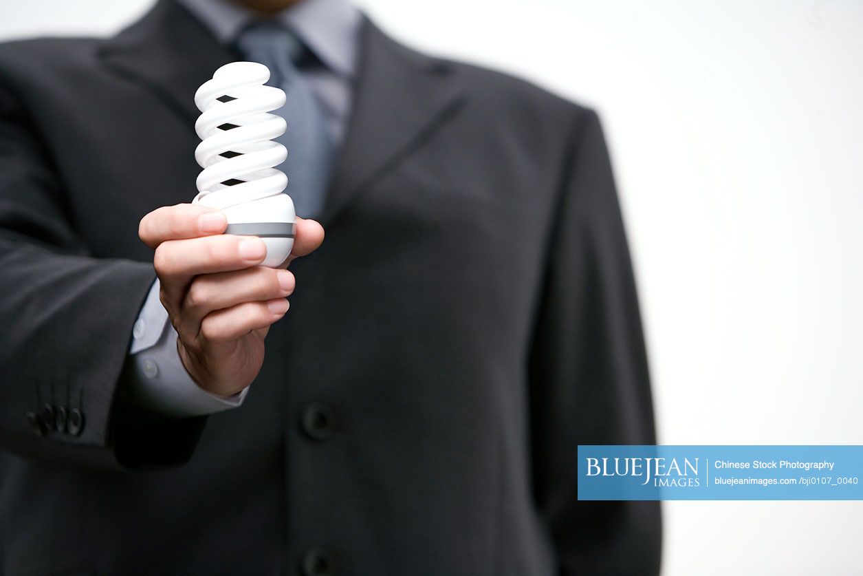 Chinese businessman holding efficient light bulb