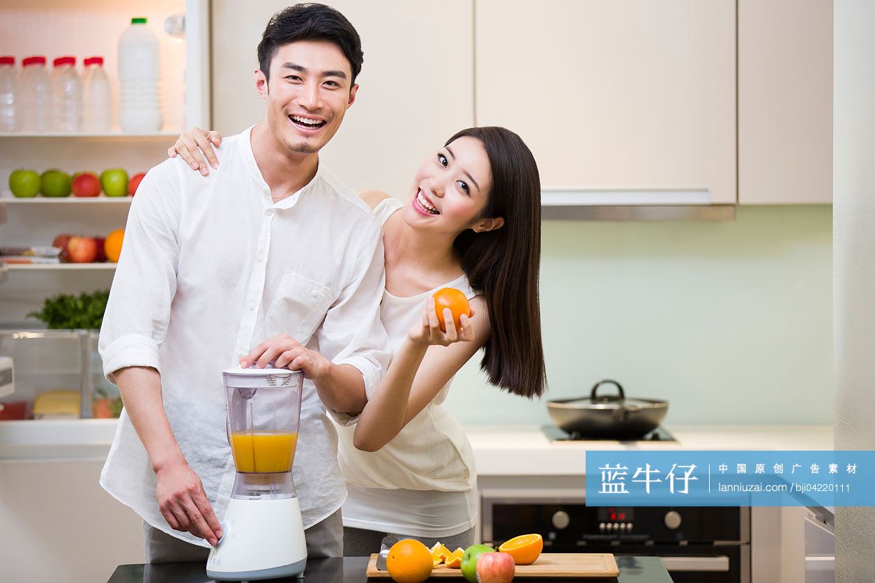 年轻夫妇在厨房使用榨汁机
