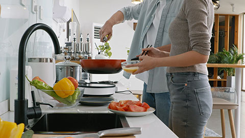 Happy young Chinese couple cooking in kitchen,4K