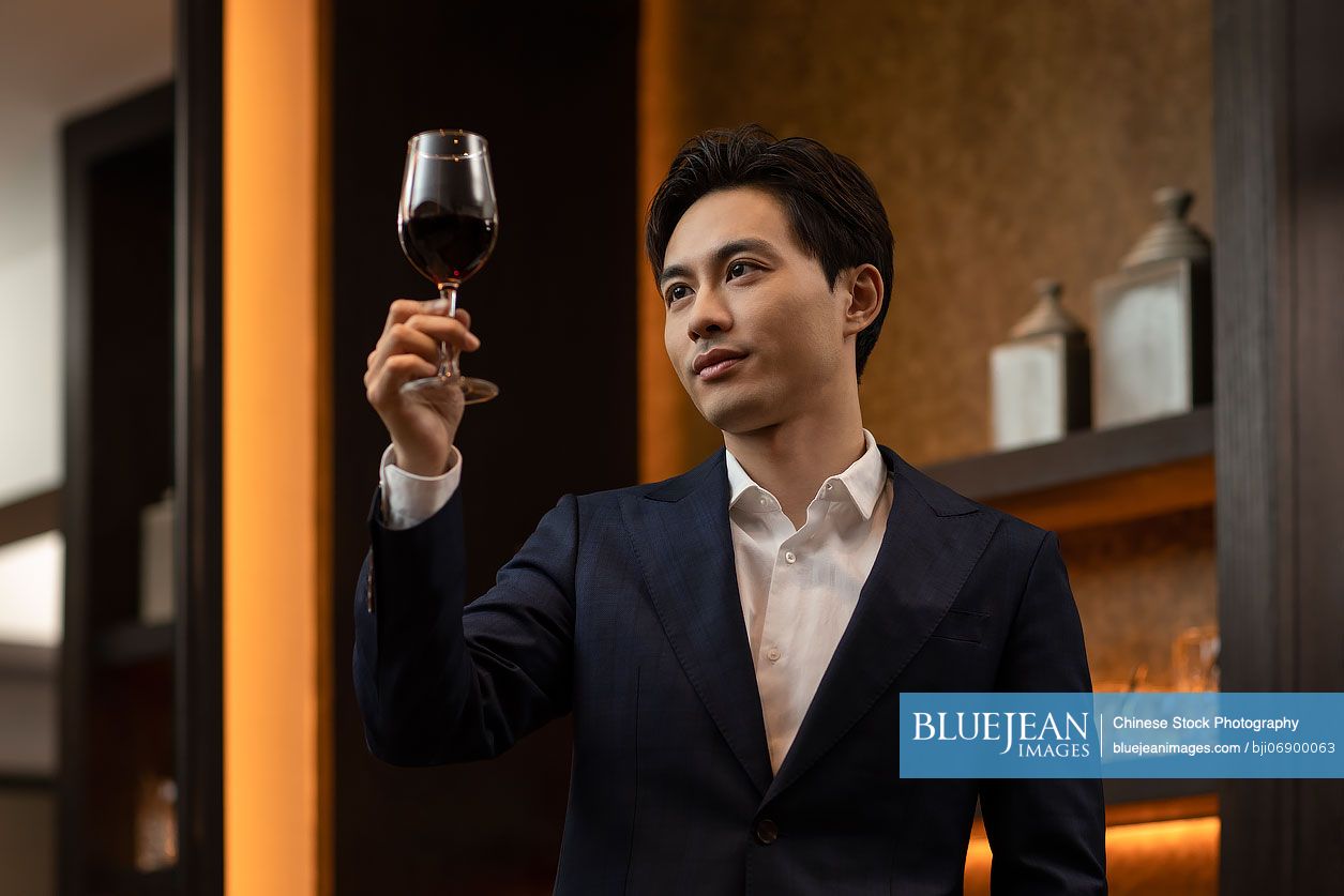 Elegant Chinese man drinking red wine