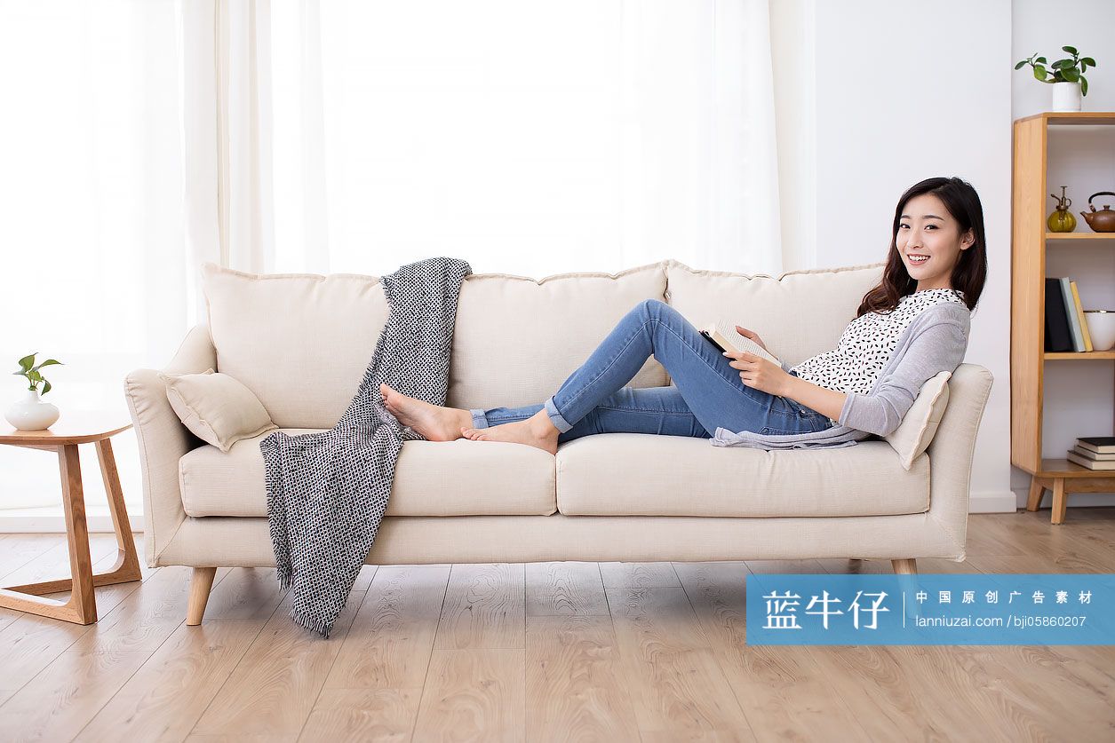 快乐的年轻女士在家看书