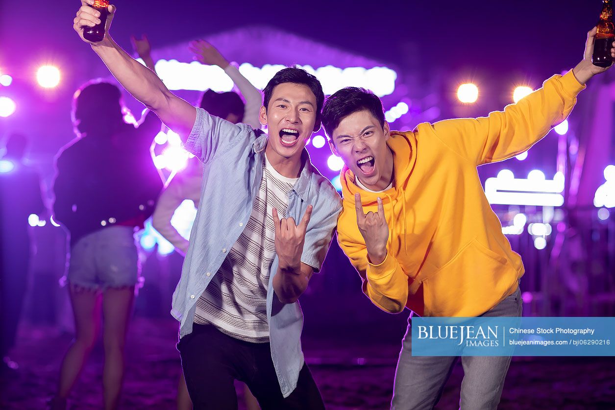 Happy young Chinese friends at music festival