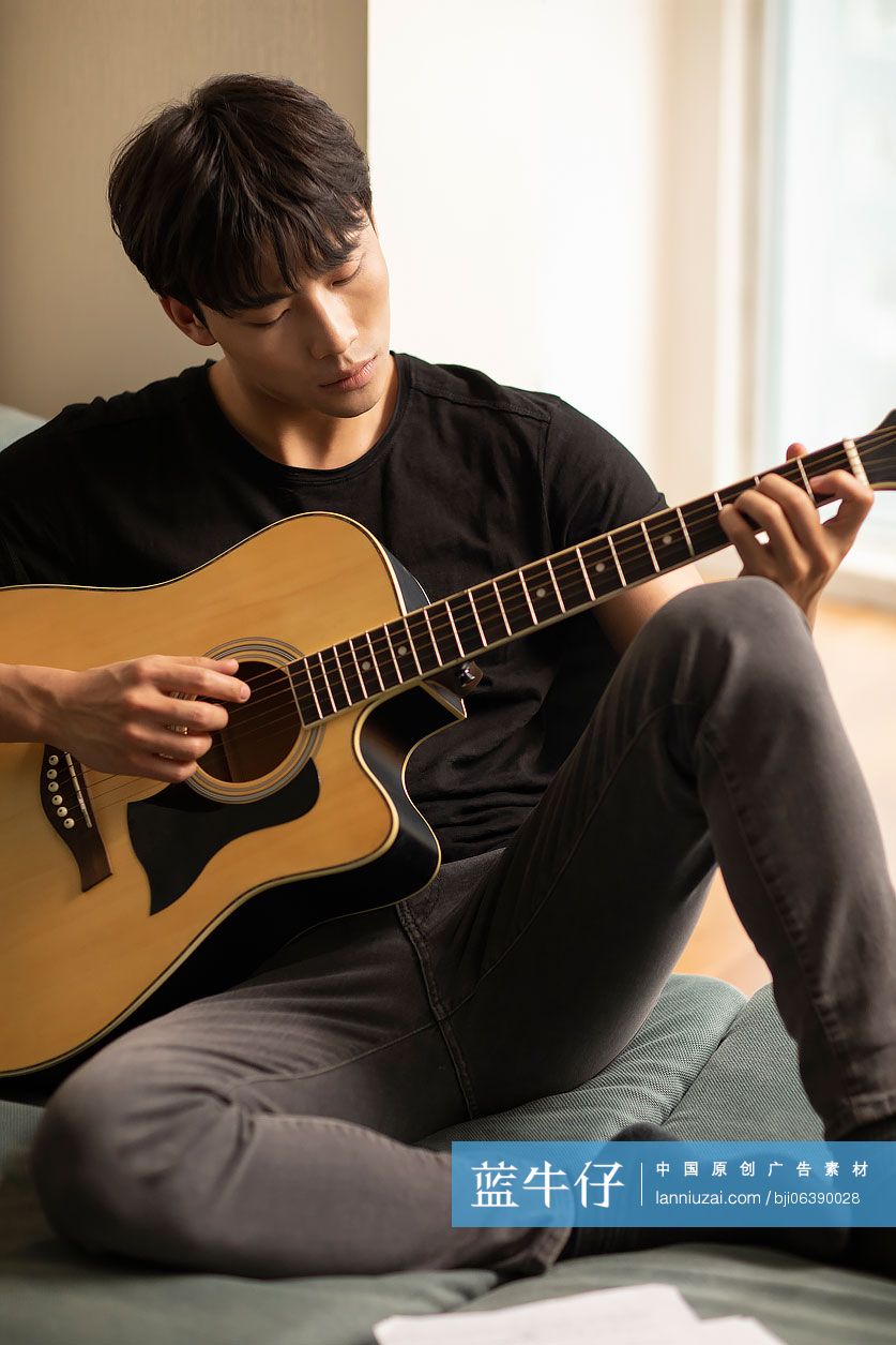 年轻男士在家弹吉他