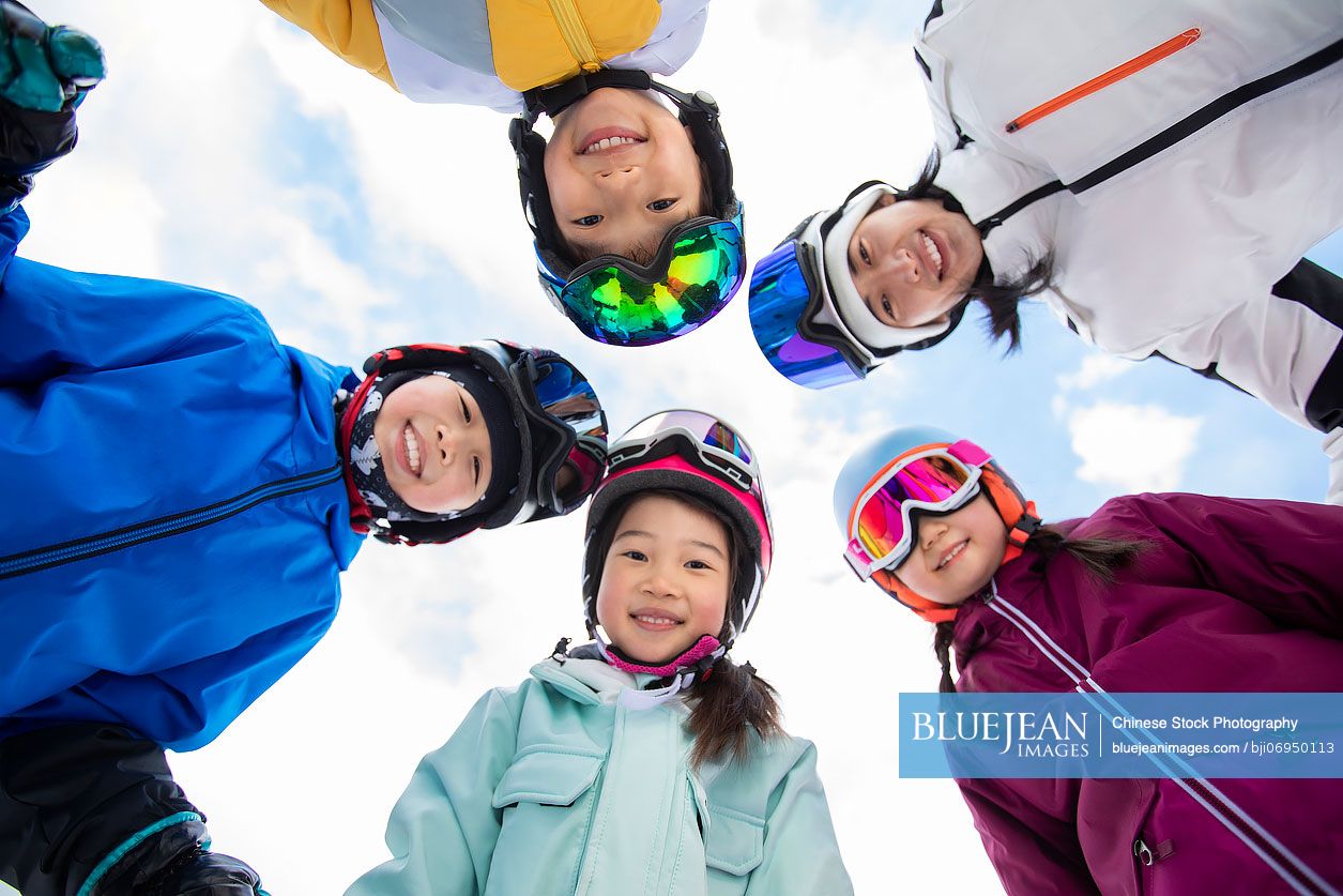 Cheerful Chinese children with their coach in ski resort