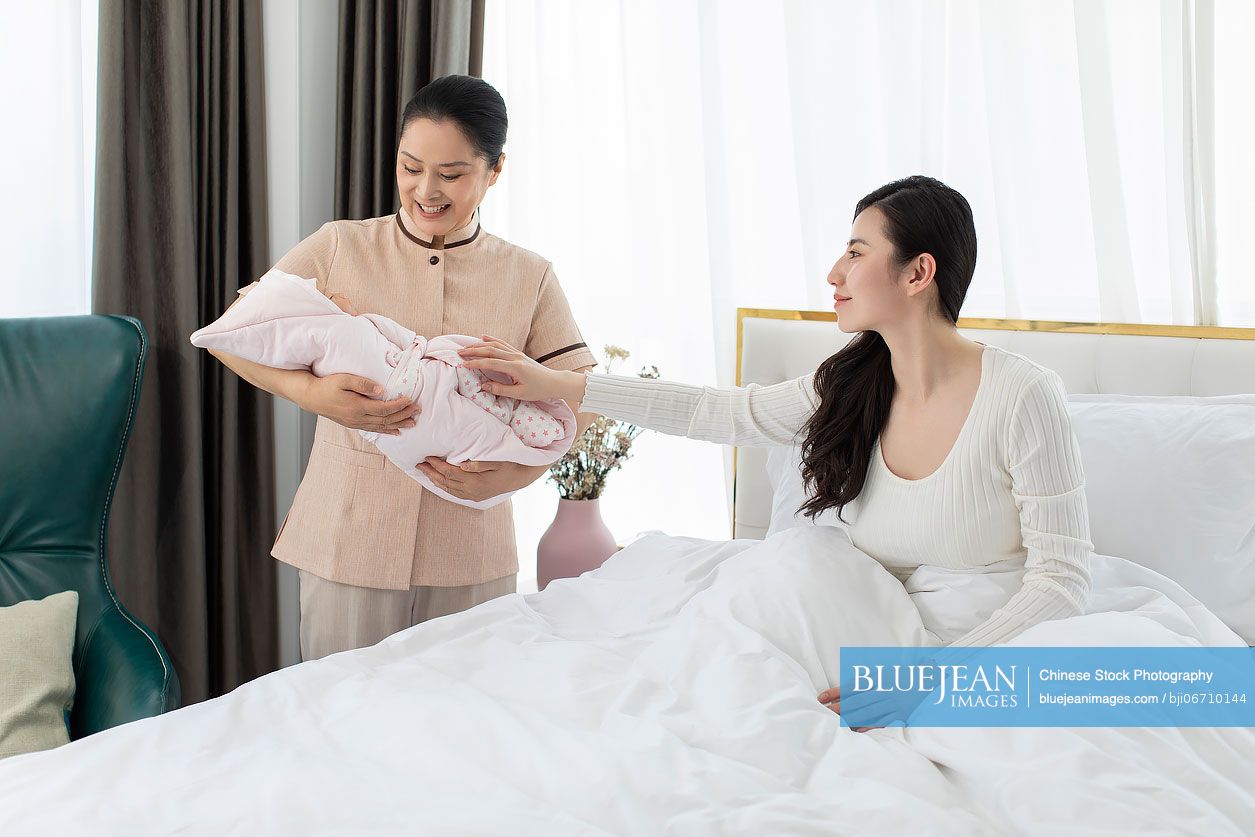 Chinese confinement nurse taking care of young mother and baby