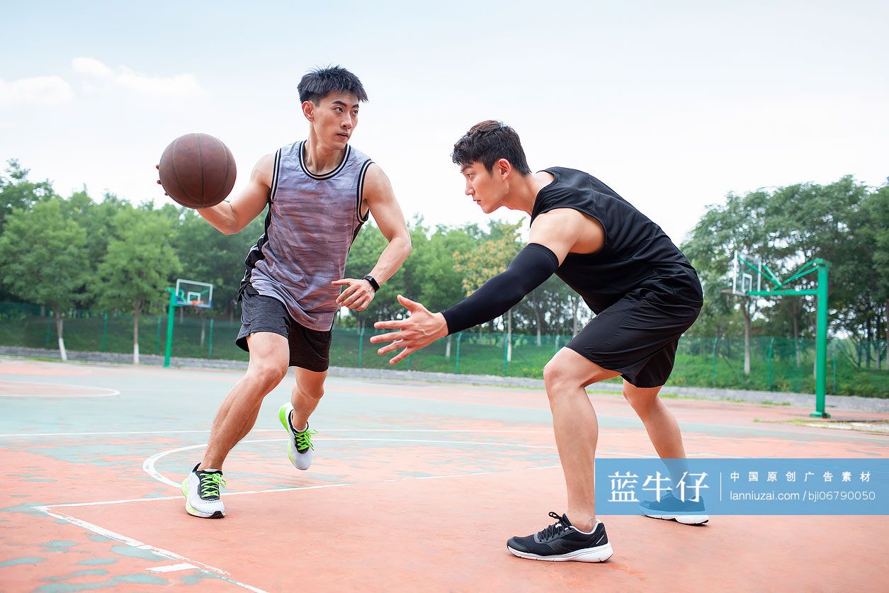 开心的年轻人在篮球场打篮球