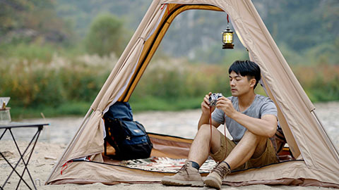 Young Chinese man taking photos outdoors