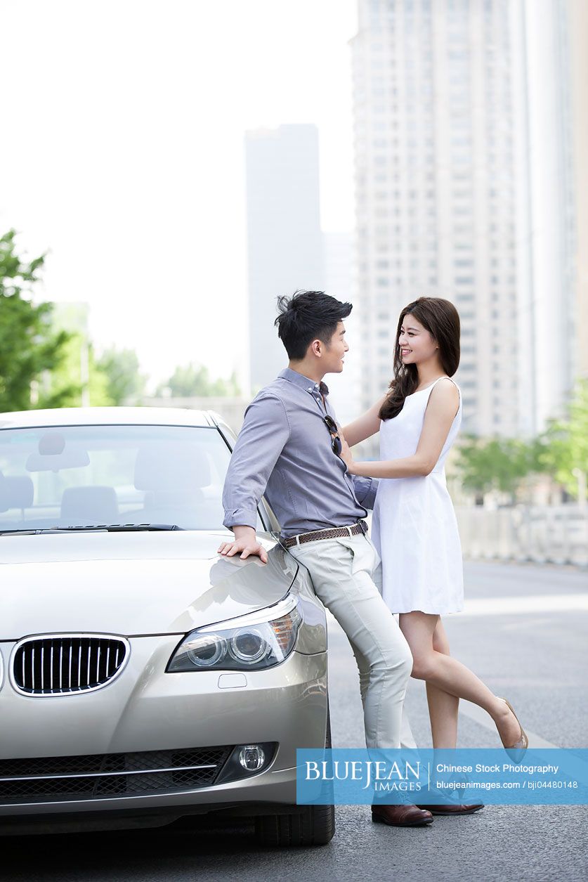 Happy young Chinese couple and car