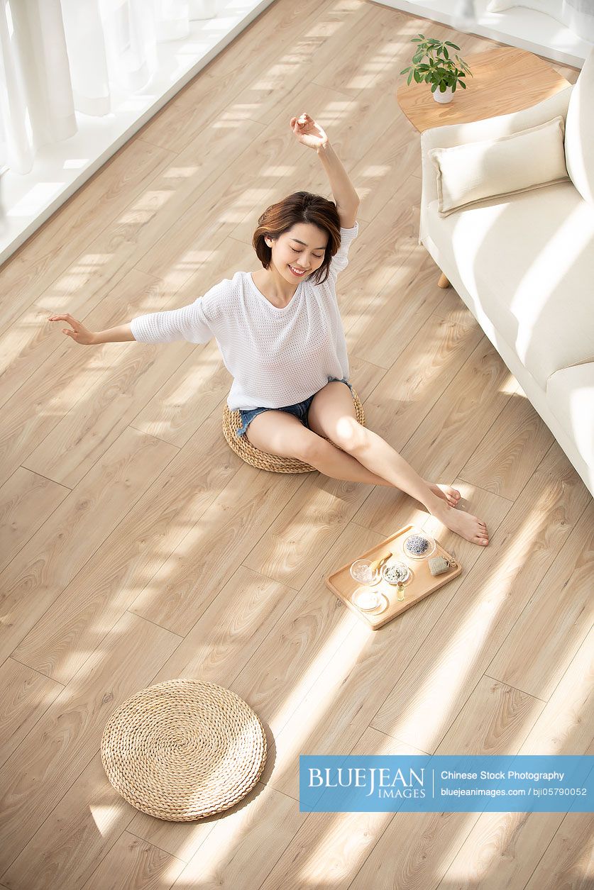 Happy young Chinese woman relaxing at home