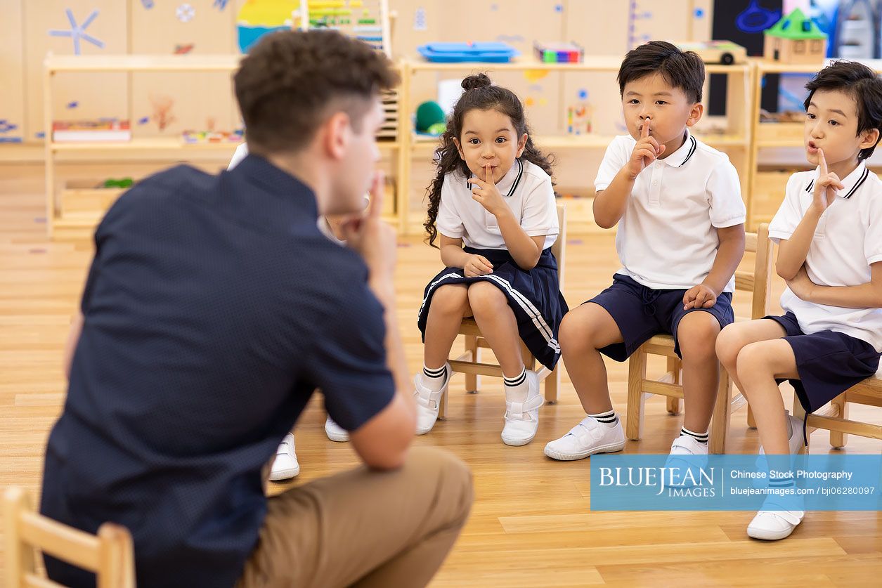 Foreign teacher and children playing games in classroom