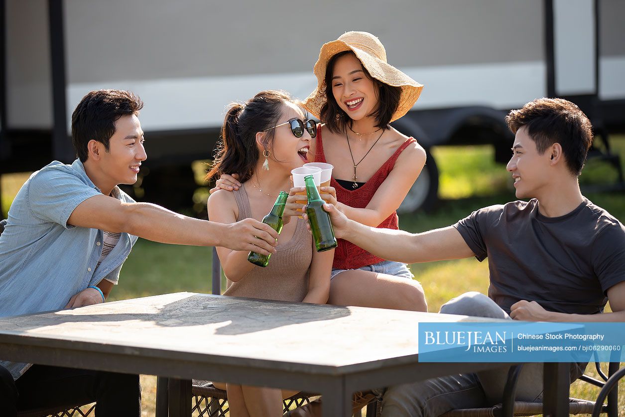 Happy young Chinese friends having a picnic outdoors