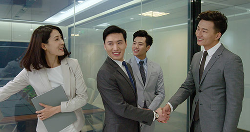 Confident Chinese business people shaking hands in office,4K
