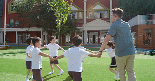 Foreign teacher and students playing in kindergarten playground,4K