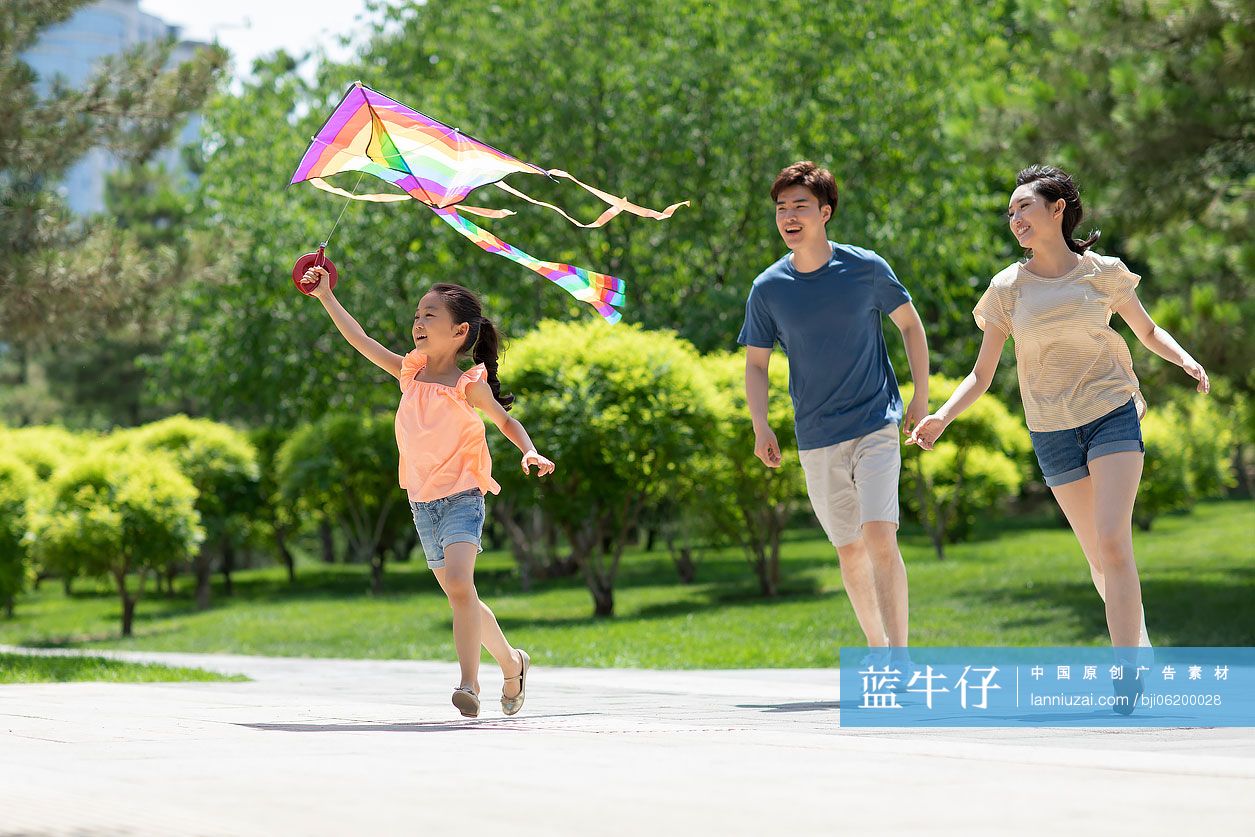 快乐的年轻家庭在公园放风筝