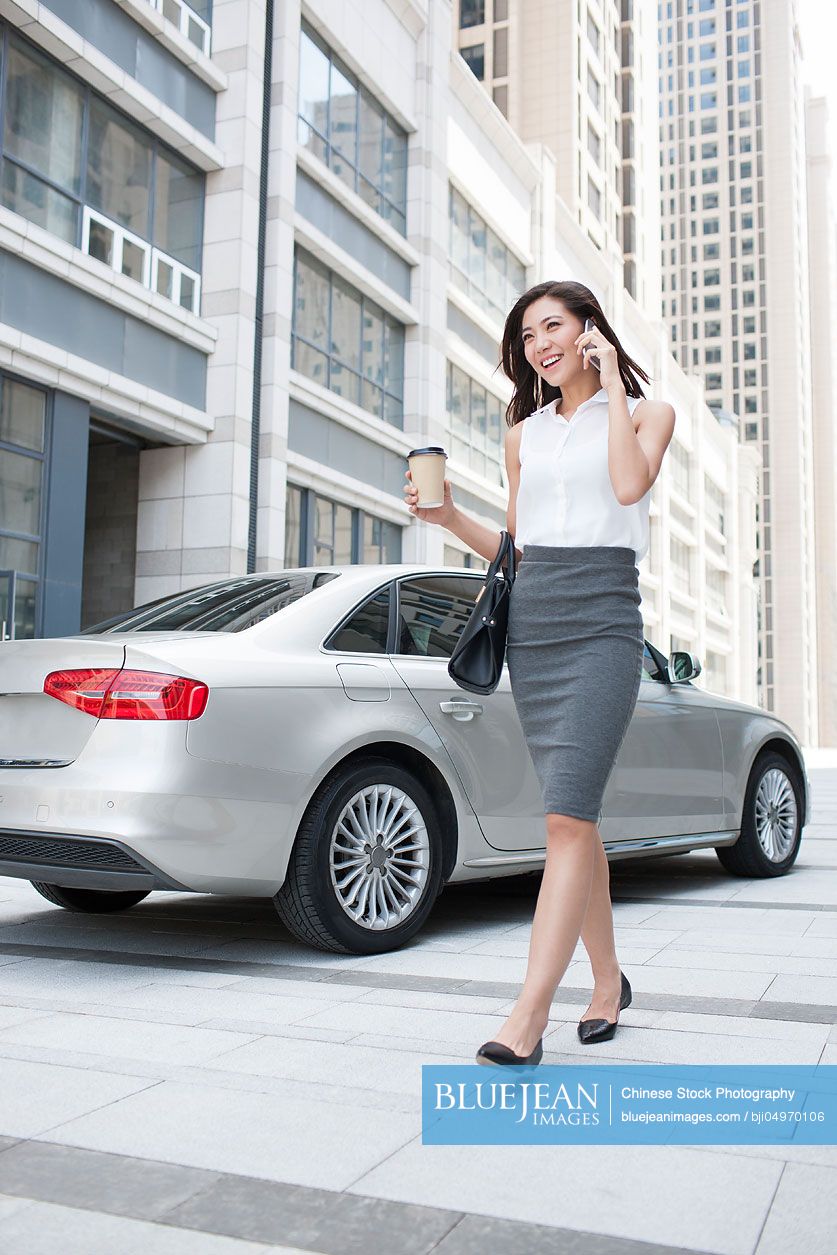 Confident Chinese businesswoman talking on cell phone