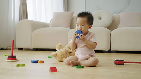 Baby playing with building blocks on the floor