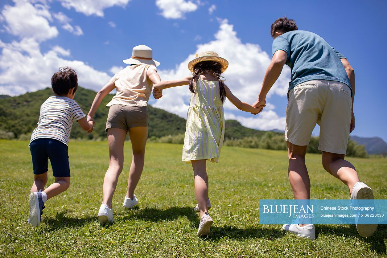 Happy young Chinese family having fun outdoors