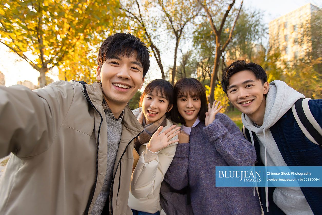 Happy Chinese college students taking selfie on campus