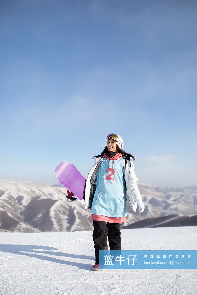 快乐的年轻女士在雪地上行走