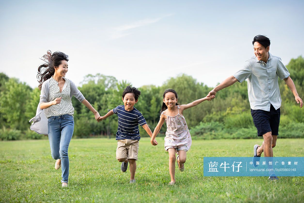 快乐年轻家庭在草地上奔跑