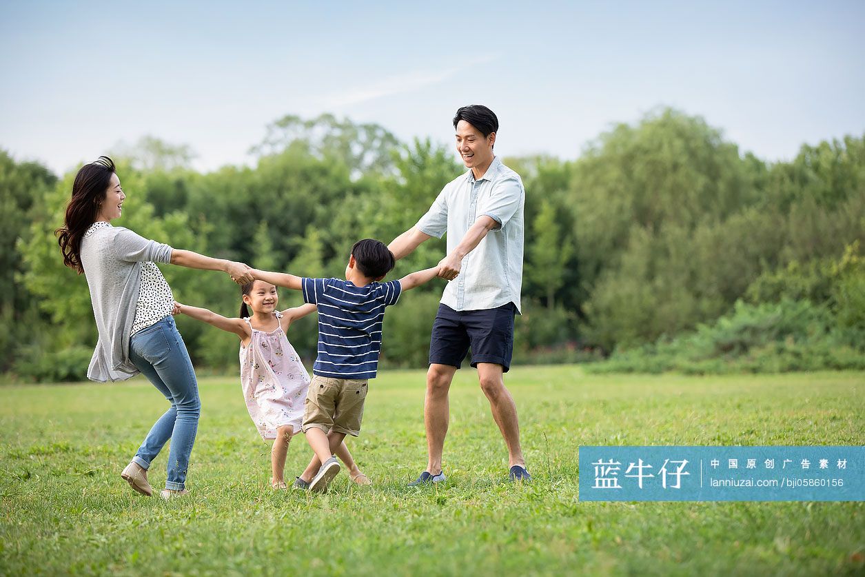 快乐年轻家庭在草地上玩耍