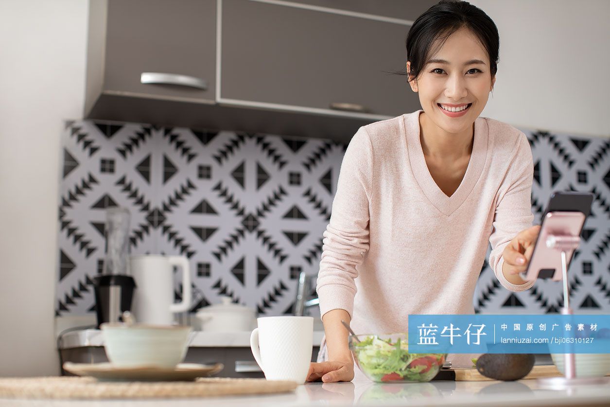 快乐年轻女士在厨房做沙拉