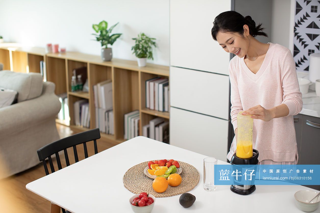 快乐年轻女士在家榨果汁