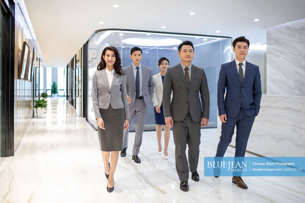 Successful Chinese business people walking in office