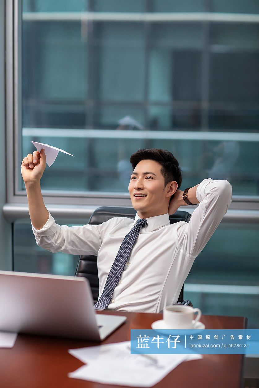 自信的商务男士在办公室扔纸飞机