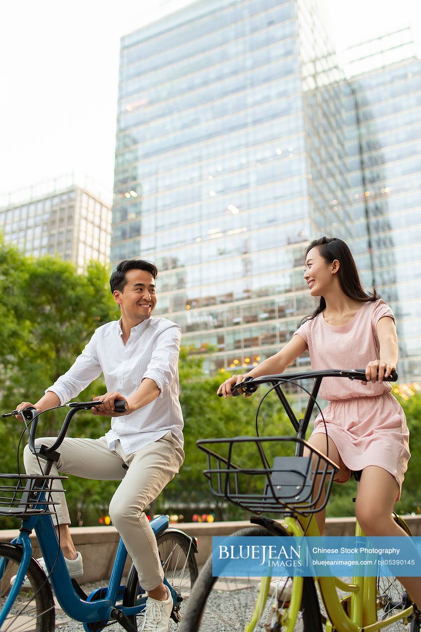 Happy young Chinese couple riding bikes