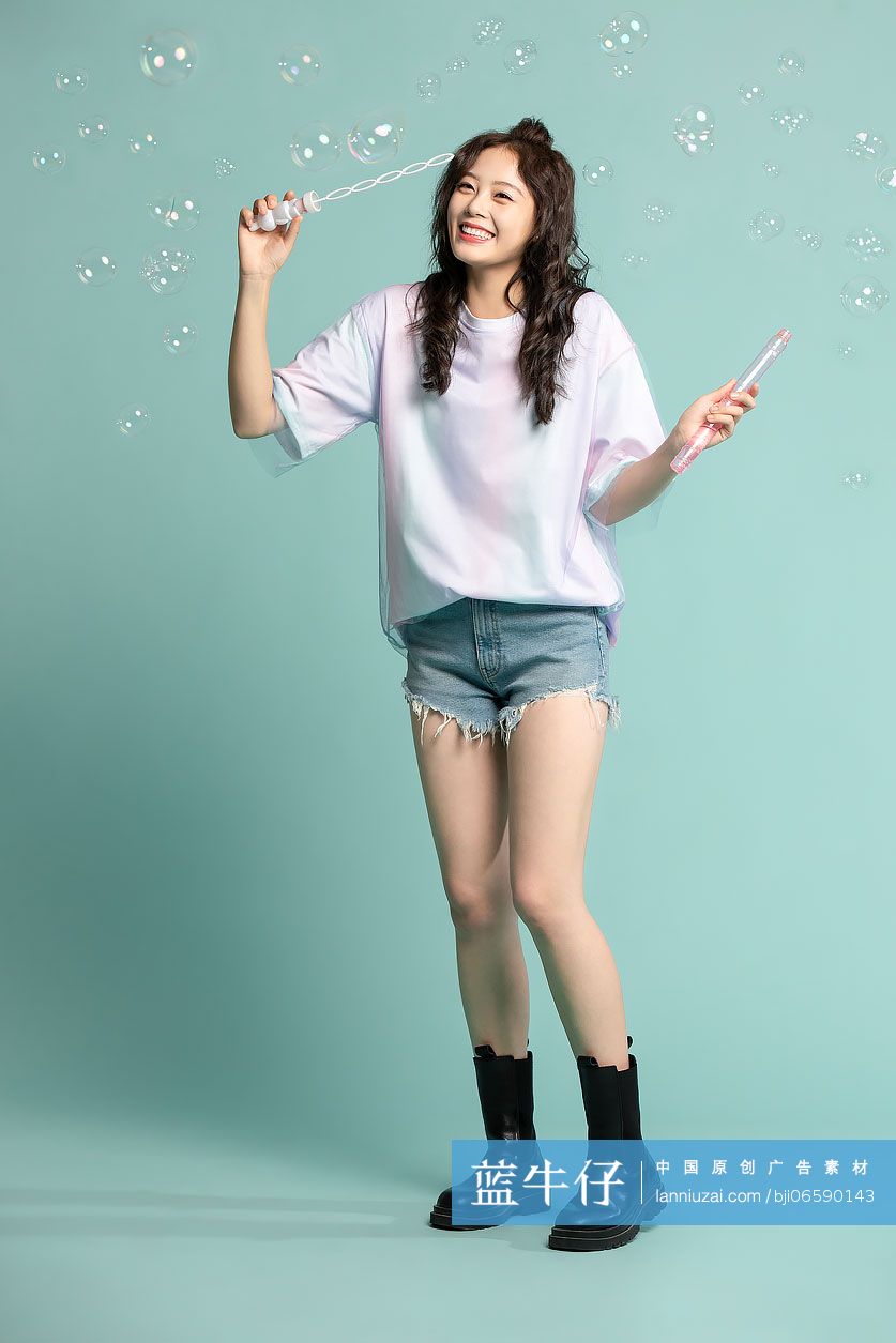 可爱的年轻女孩吹泡泡