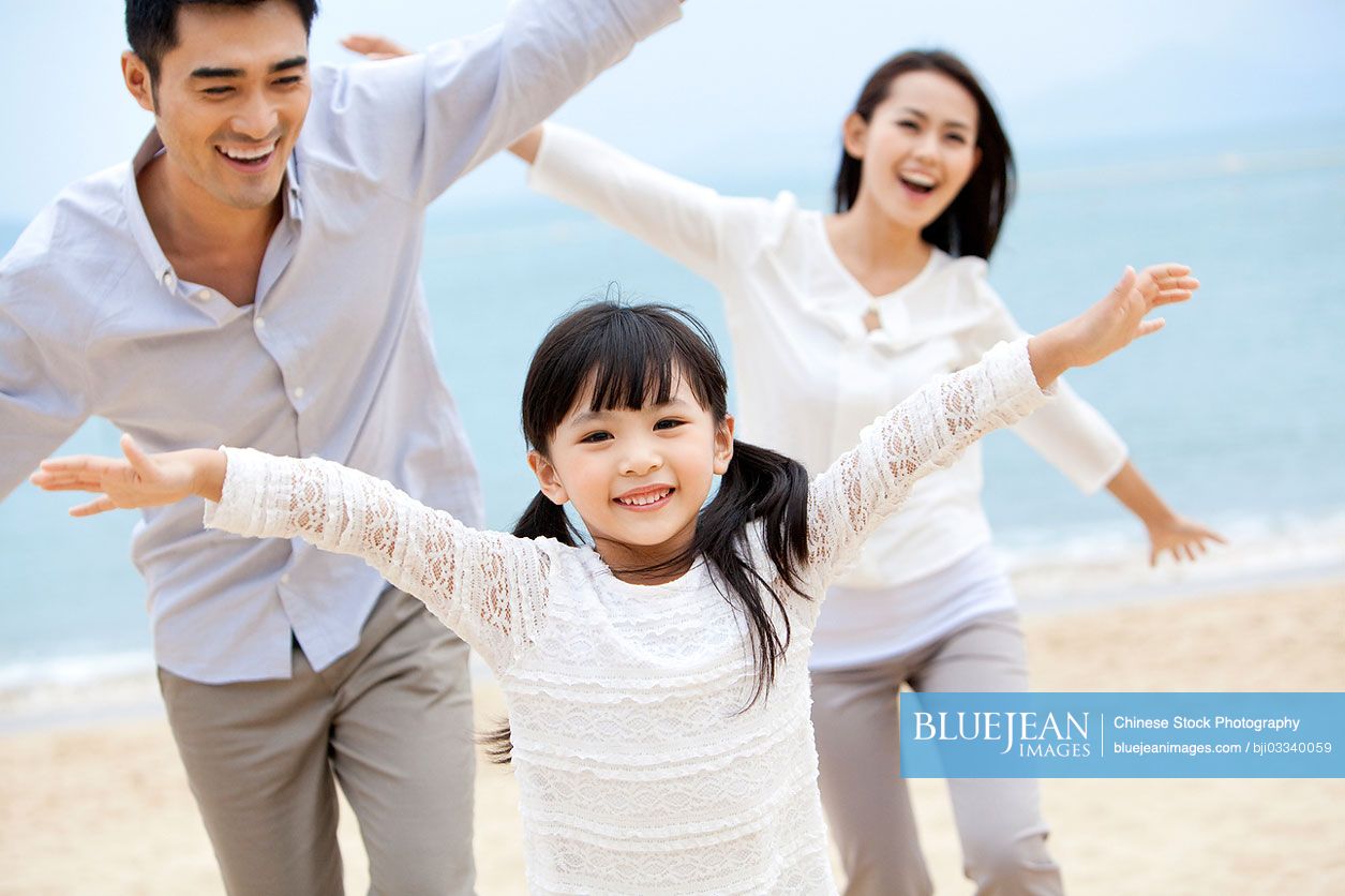 Sweet moment among young Chinese family on the beach of Repulse Bay, Hong Kong