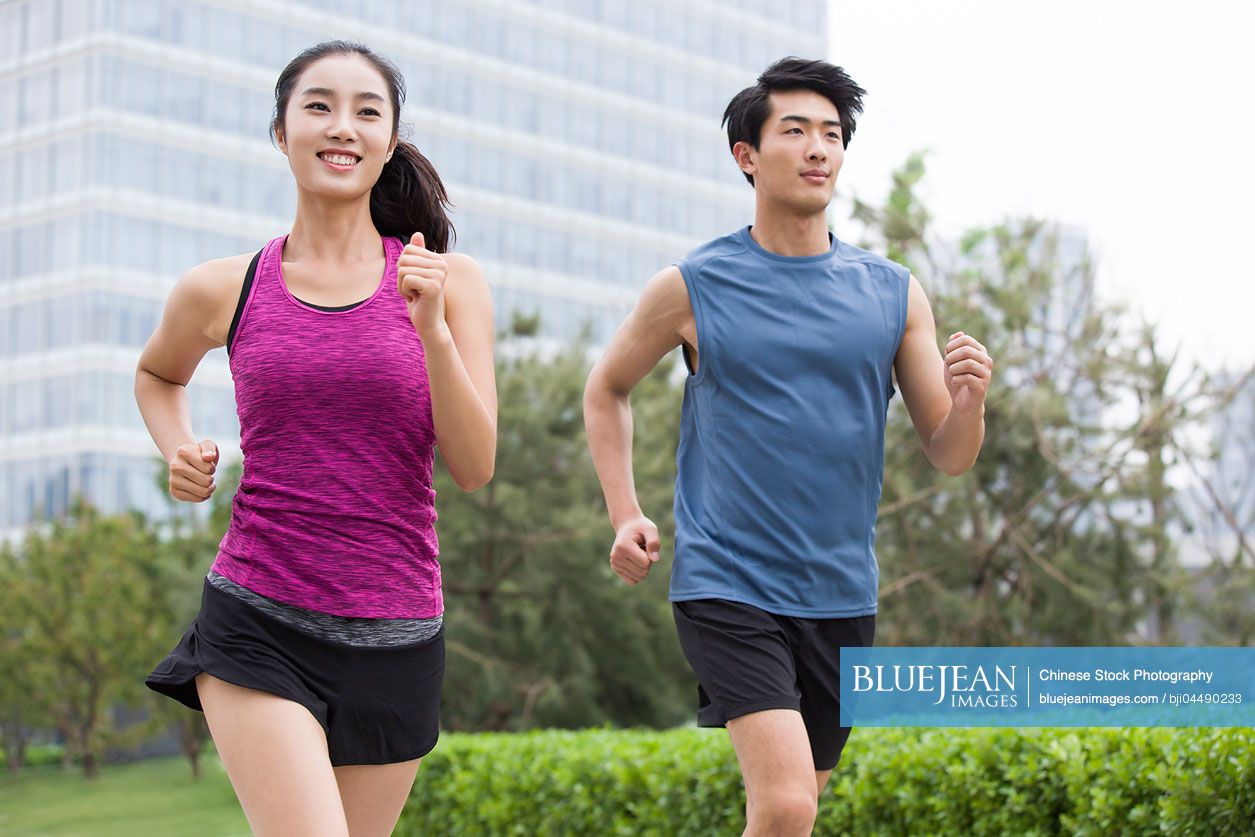 Young Chinese couple running outside