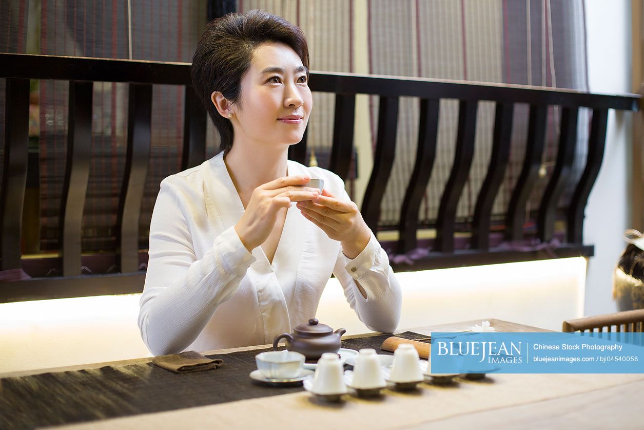 Mid adult Chinese woman performing tea ceremony