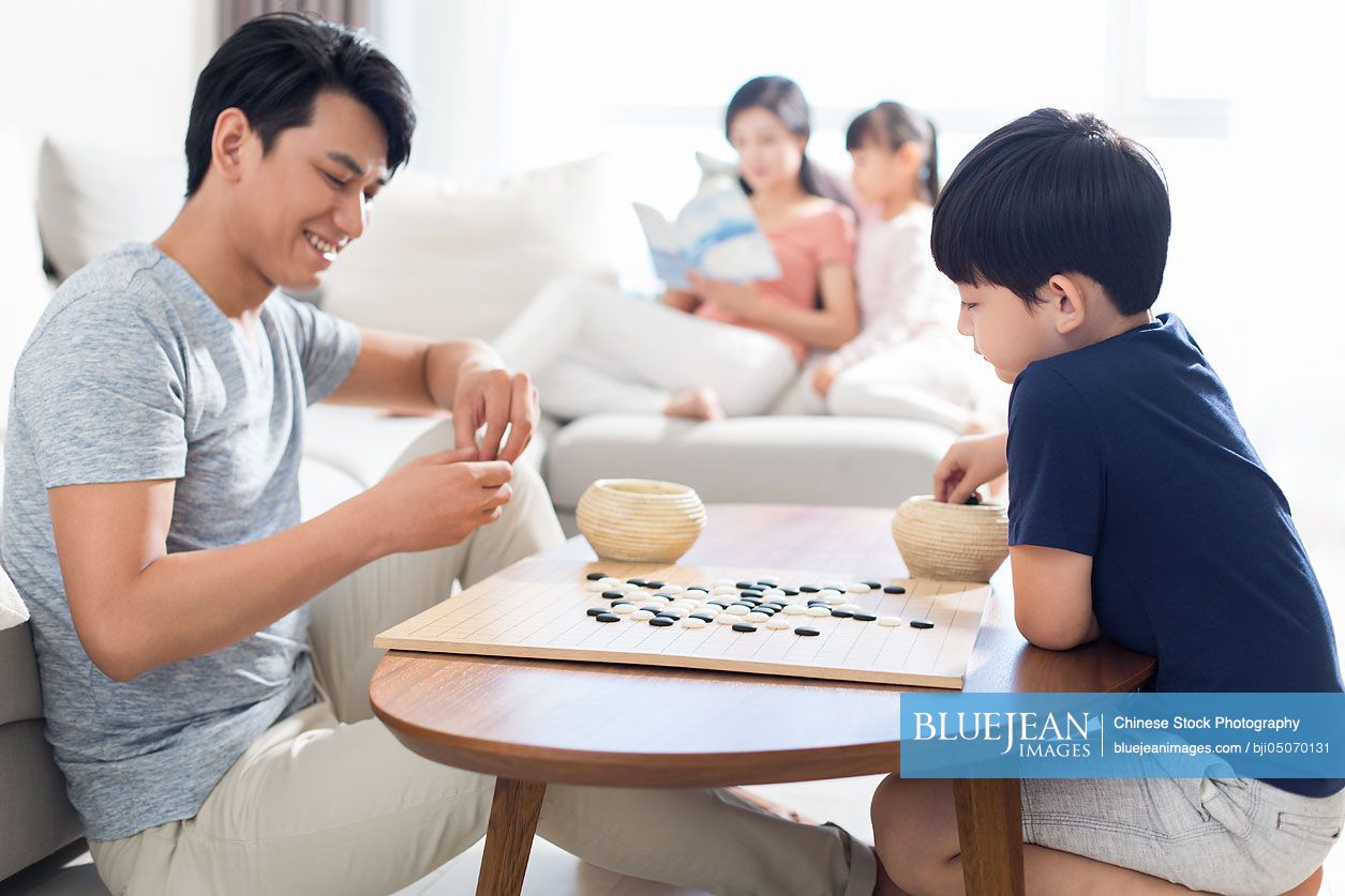 Little Chinese boy playing the game of Go with father