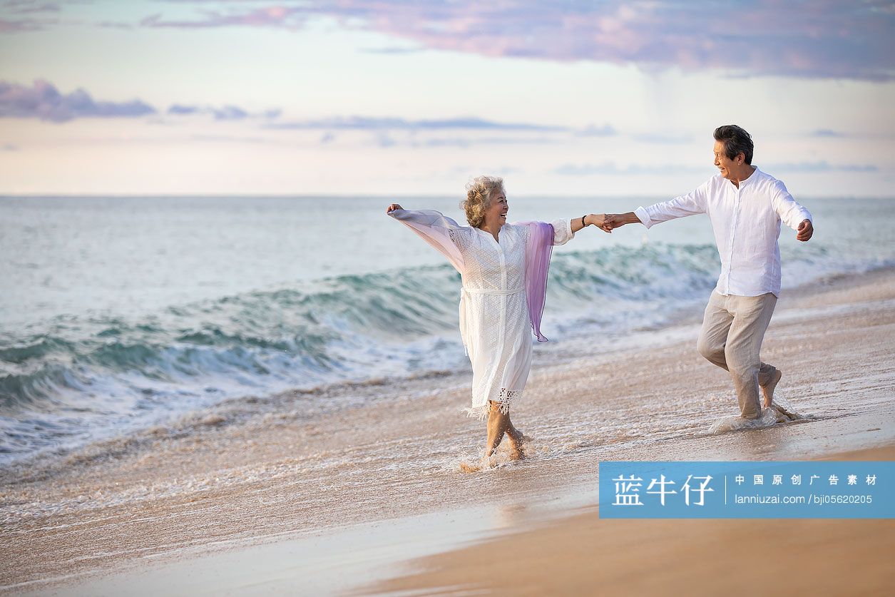 快乐的老年夫妇在沙滩跳舞