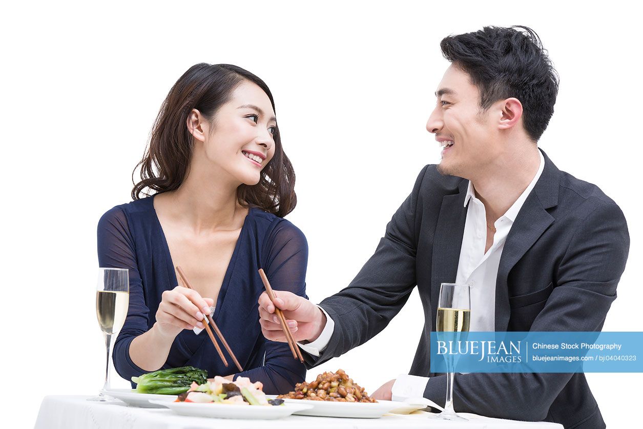 Happy young Chinese couple having dinner