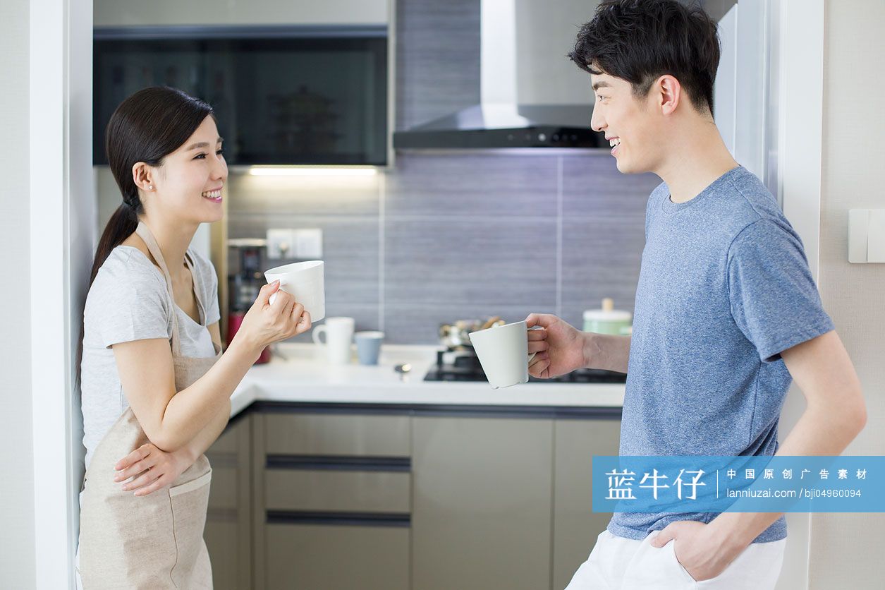 快乐的年轻夫妇在厨房喝咖啡