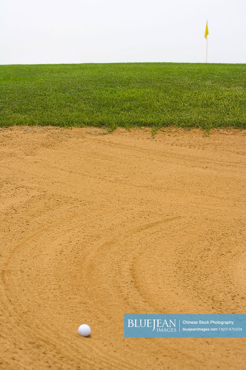 Golf ball in sand bunker