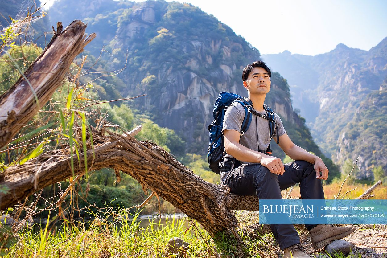 Young Chinese man hiking outdoors