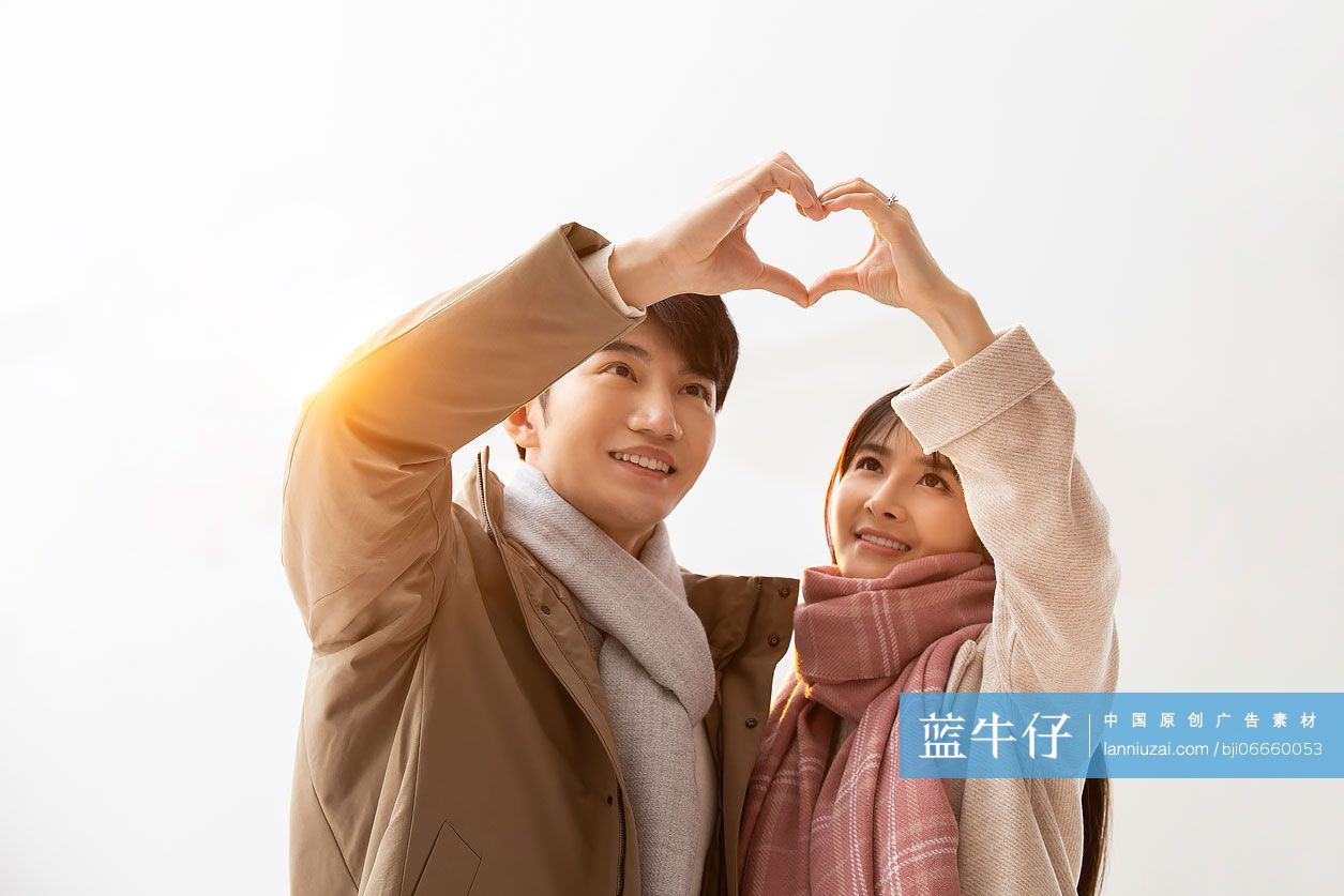 甜蜜的年轻情侣摆心型手势