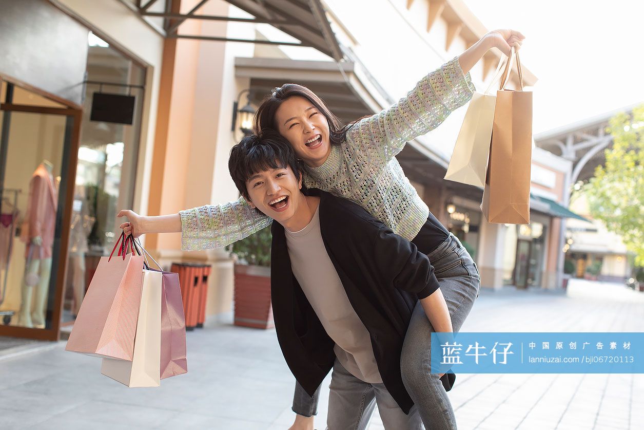 快乐的年轻情侣逛街购物-蓝牛仔影像-中国原创广告影像素材